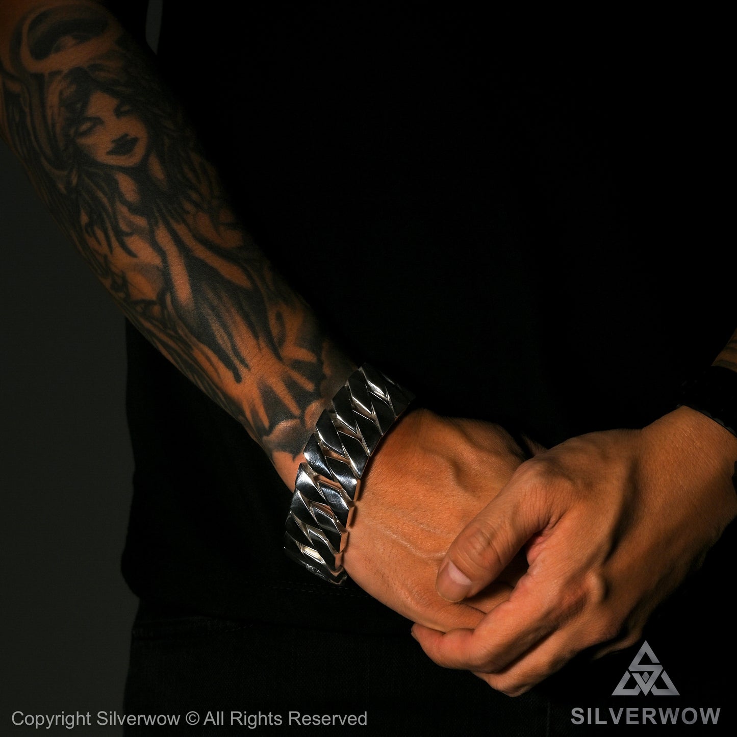 chunky silver bracelet on arm – worn with tattoo sleeve for bold look