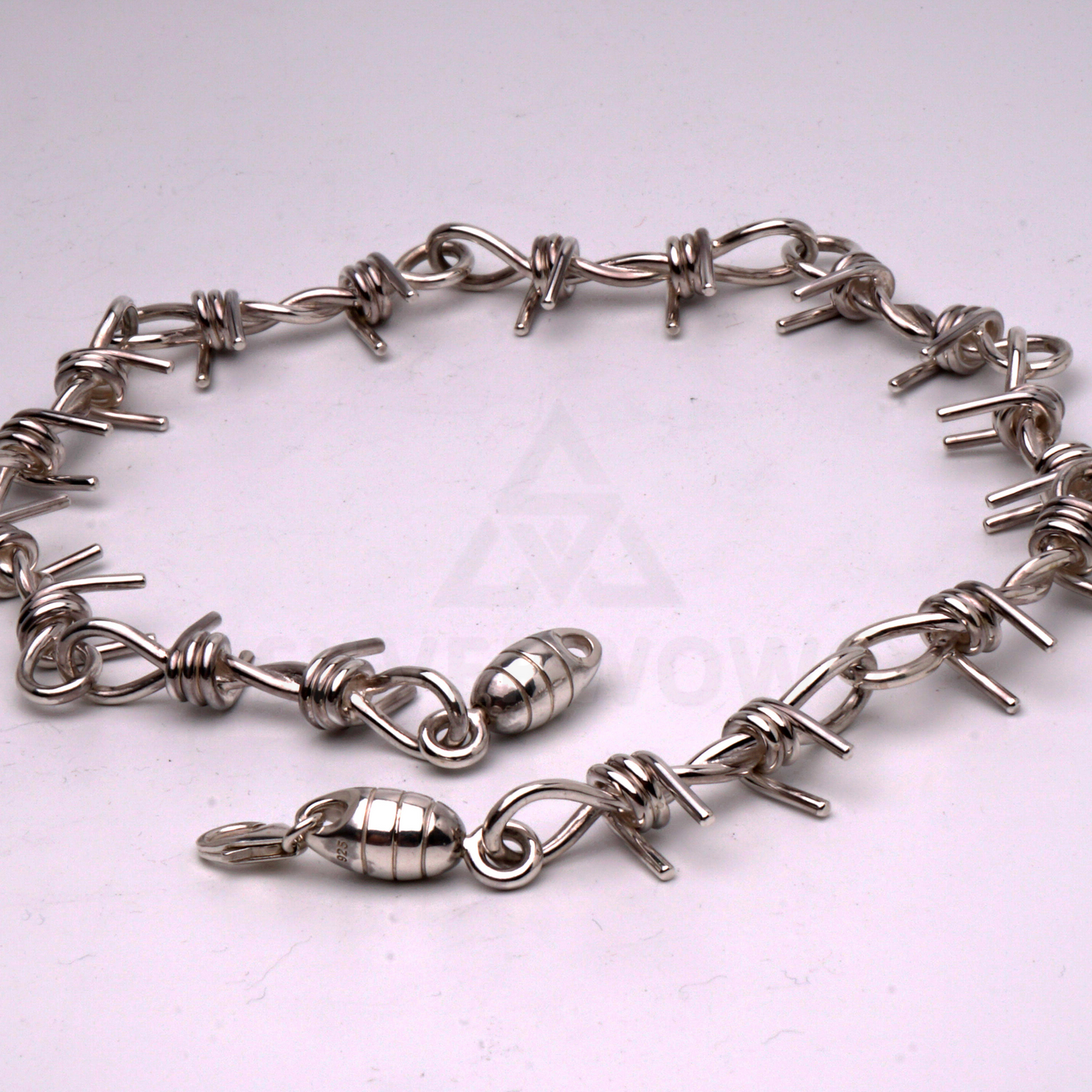 Barbed wire necklace in solid silver laid flat in a circular shape to show design
