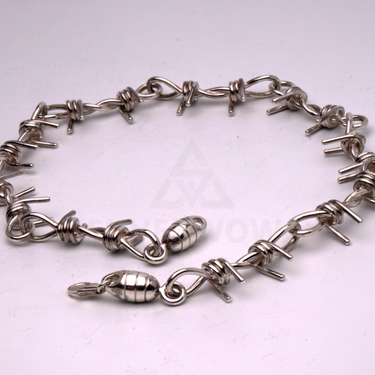 Barbed wire necklace in solid silver laid flat in a circular shape to show design